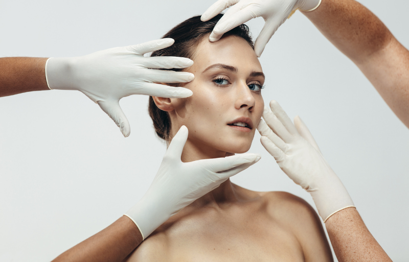 visage d'une femme entourée de mains médicales